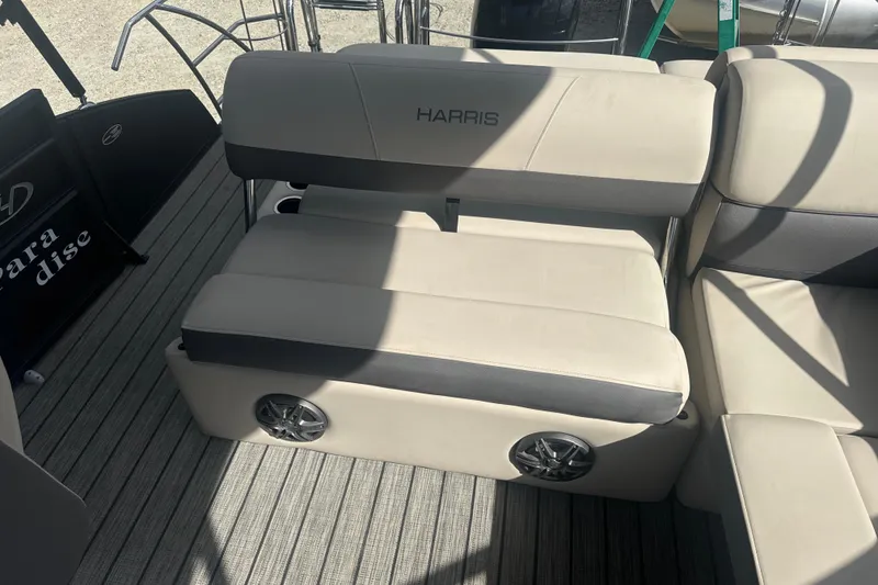 Slide: The Image of 2023 Harris HCX 230 Swingback boat seat with integrated speakers on a striped deck. - 17