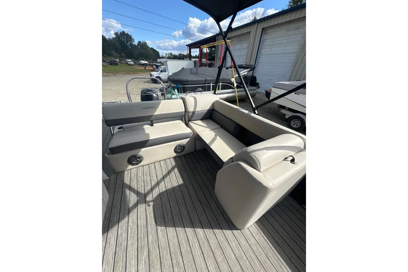 Slide: The Image of 2023 Harris HCX 230 Swingback boat interior with beige seating and speakers. - 18