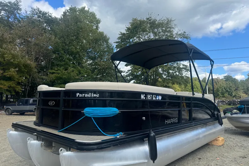Slide: The Image of 2023 Harris HCX 230 Swingback pontoon boat with canopy, parked outdoors. - 2