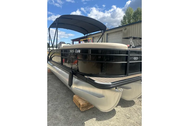 Slide: The Image of 2023 Harris HCX 230 Swingback pontoon boat with canopy, parked outdoors. - 21