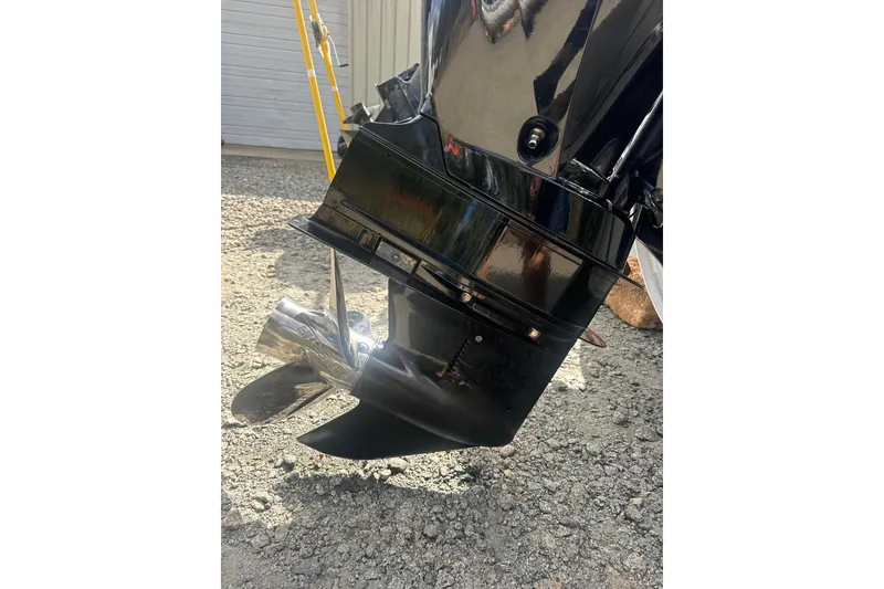 Slide: The Image of 2023 Harris HCX 230 Swingback boat motor and propeller on gravel surface. - 26