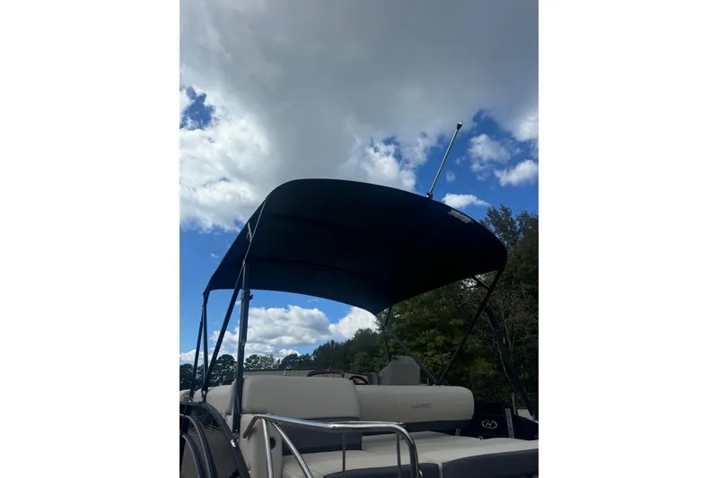 Slide: The Image of 2023 Harris HCX 230 Swingback boat with canopy under cloudy sky. - 6