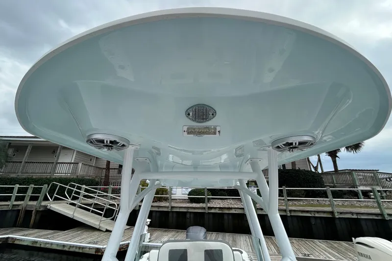 Slide: The Image of 2016 Sea Fox 246 Commander boat with T-top and speakers, docked near a wooden pier. - 17