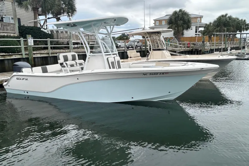 Slide: The Image of 2016 Sea Fox 246 Commander boat docked in a marina, calm water reflection. - 3
