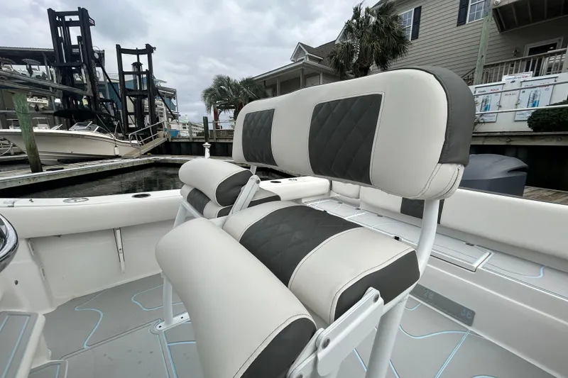 Slide: The Image of 2016 Sea Fox 246 Commander boat interior with cushioned seating at a marina. - 8