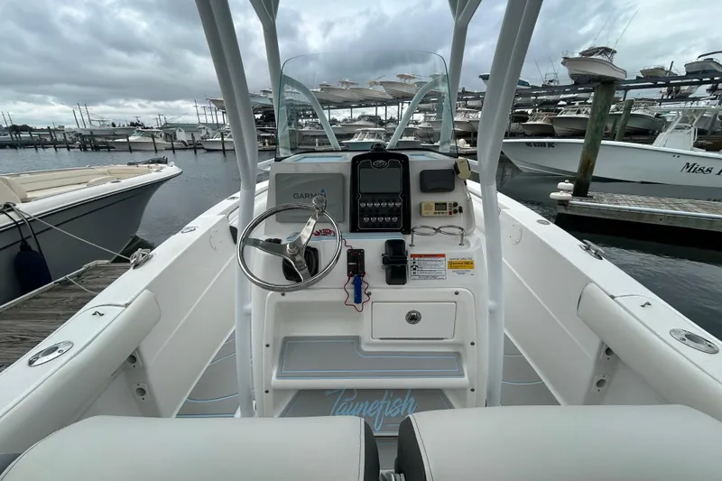 Slide: The Image of 2016 Sea Fox 246 Commander boat dashboard with steering wheel, docked at marina. - 9