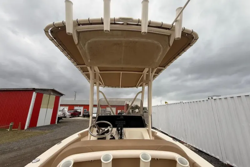 Slide: The Image of 2023 Scout 215 XSF boat with T-top, docked under cloudy skies. - 12
