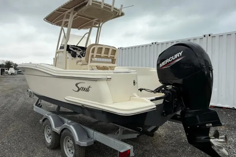 Slide: The Image of 2023 Scout 215 XSF boat with Mercury engine on trailer, outdoor setting. - 4
