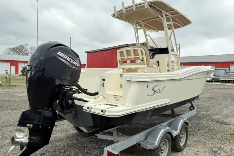 Slide: The Image of 2023 Scout 215 XSF boat with Mercury engine on trailer, parked outdoors. - 5