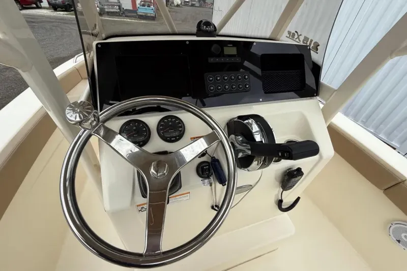 Slide: The Image of 2023 Scout 215 XSF boat dashboard with steering wheel and control panel. - 8