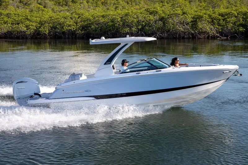 Slide: The Image of Manufacturer Provided Image: 2026 Chaparral 270 OSX boat cruising on a calm waterway with lush greenery. - 2