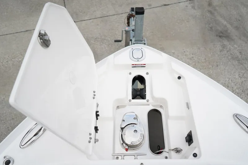 Slide: The Image of 2026 Chaparral 270 OSX boat anchor compartment with open hatch, showcasing storage features. - 26