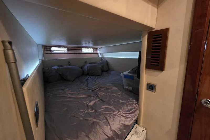 Slide: The Image of Cozy cabin interior of 2010 Sea Ray 470 Sundancer yacht with bed and porthole windows. - 10