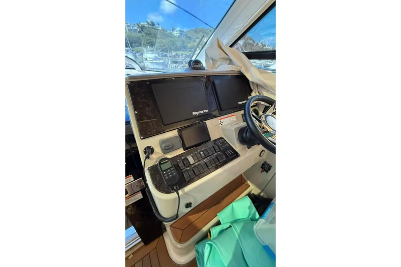 Slide: The Image of 2010 Sea Ray 470 Sundancer helm with Raymarine navigation system and steering wheel. - 12