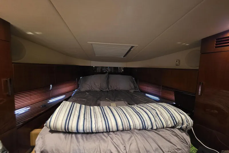 Slide: The Image of Cozy cabin interior of 2010 Sea Ray 470 Sundancer yacht with bed and wooden accents. - 3