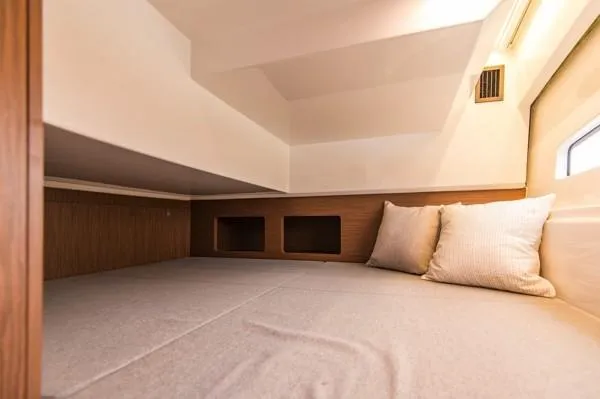 Slide: The Image of 2024 Beneteau Antares 9 cabin interior with cozy bedding and pillows. - 15
