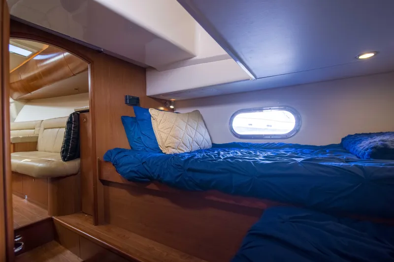 Slide: The Image of 2010 Luhrs Canyon Express cabin interior with cozy bedding and porthole window. - 45