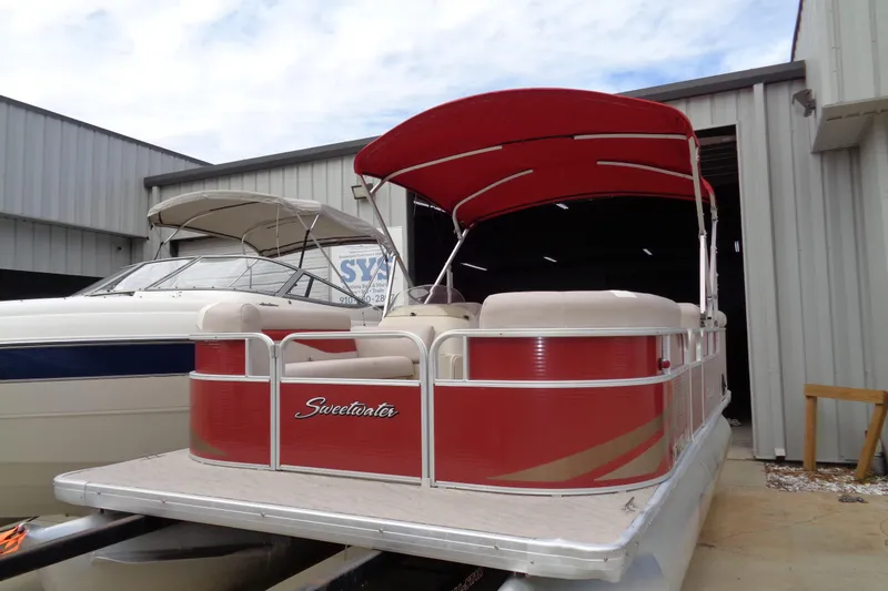 Slide: The Image of 2014 Sweetwater 2086 DFS pontoon boat with red canopy, docked near a warehouse. - 3