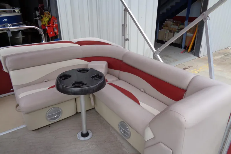 Slide: The Image of 2014 Sweetwater 2086 DFS boat interior with beige and red seating, cupholder table. - 7