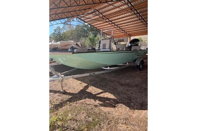 Slide: The Image of 2024 G3 Bay 20 GX boat under a metal canopy, on a trailer. - 9