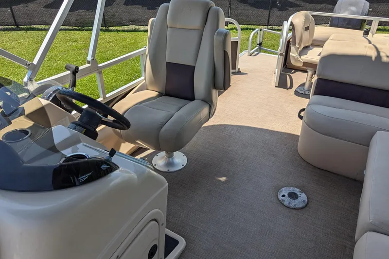 Slide: The Image of 2019 Sun Tracker Fishin' Barge 24 DLX interior with seating and steering console. - 10