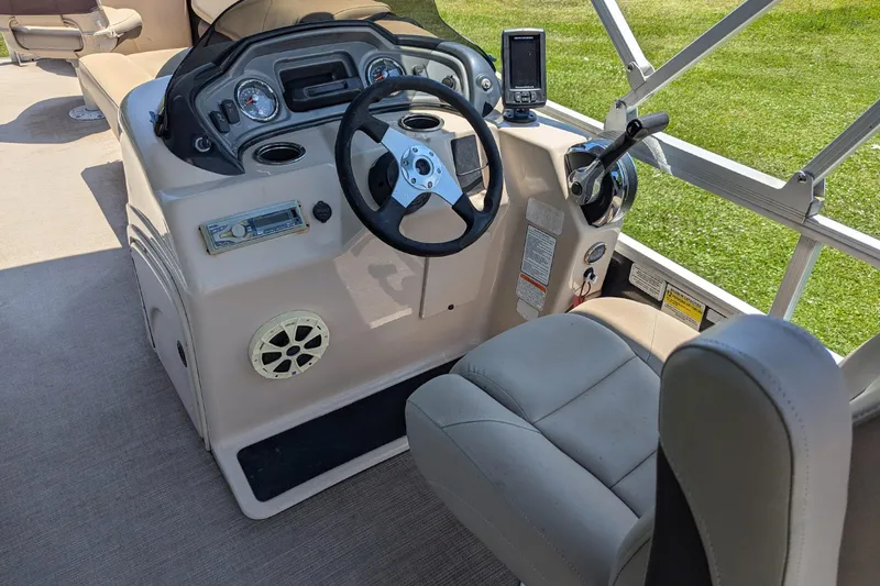 Slide: The Image of 2019 Sun Tracker Fishin' Barge 24 DLX helm with steering wheel and control panel. - 11