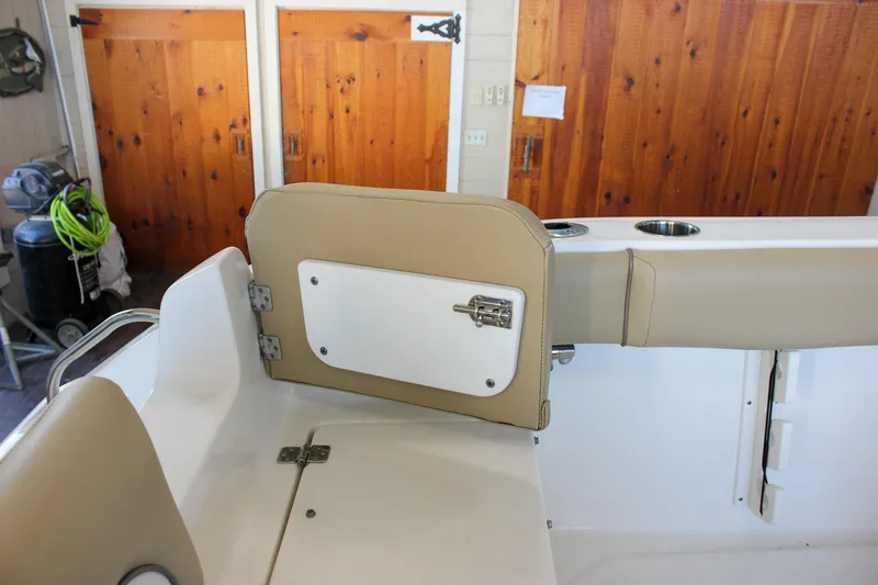 Slide: The Image of 2018 Key West 219 FS boat interior with tan seating and storage compartment. - 17