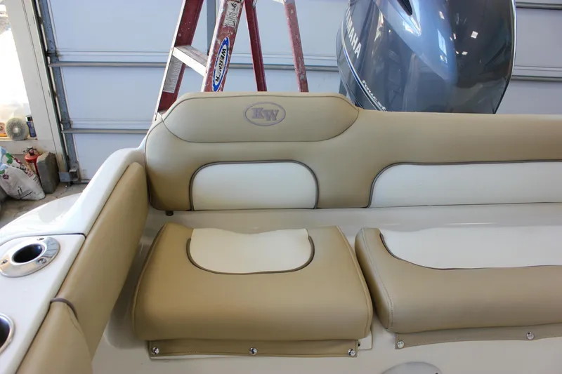 Slide: The Image of 2018 Key West 219 FS boat interior with beige and white seating, Yamaha engine visible. - 19