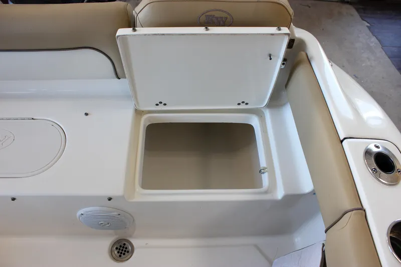 Slide: The Image of 2018 Key West 219 FS boat storage compartment with open lid and beige seating. - 23