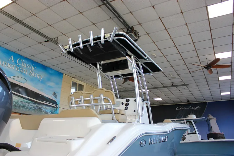 Slide: The Image of 2018 Key West 219 FS boat displayed in showroom with promotional banners. - 4