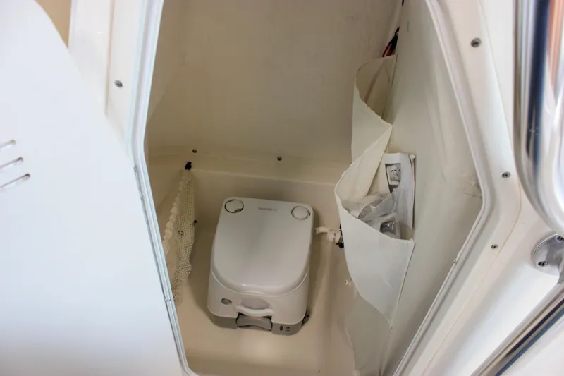Slide: The Image of 2018 Key West 219 FS boat interior with compact marine toilet and storage compartments. - 41