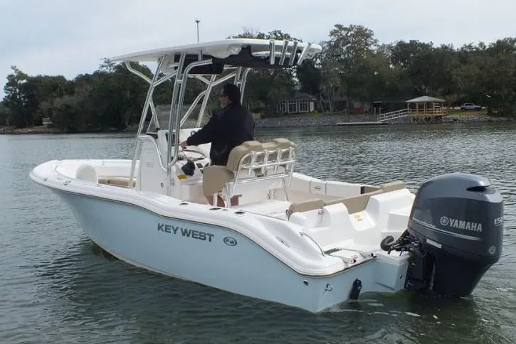 Slide: The Image of 2018 Key West 219 FS boat covered on a Venture trailer, parked on gravel. - 62