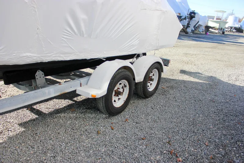 Slide: The Image of 2018 Key West 219 FS boat on trailer, covered, parked on gravel. - 64