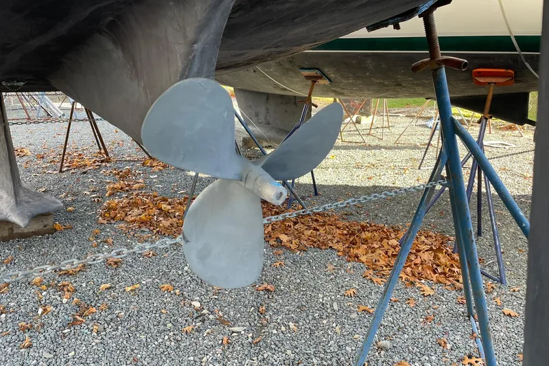 Slide: The Image of Propeller of 2000 Beneteau Oceanis 361 sailboat on stands, surrounded by autumn leaves. - 24