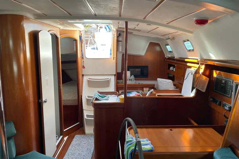 Slide: The Image of Interior of 2000 Beneteau Oceanis 361 sailboat, featuring wood finishes and cozy cabin layout. - 26
