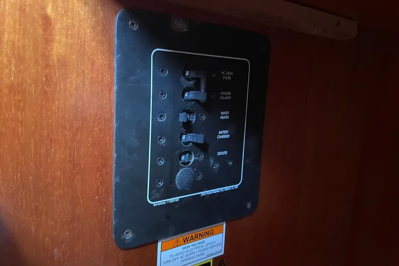 Slide: The Image of Electrical panel on a 2000 Beneteau Oceanis 361 sailboat, featuring various switches and warning label. - 30