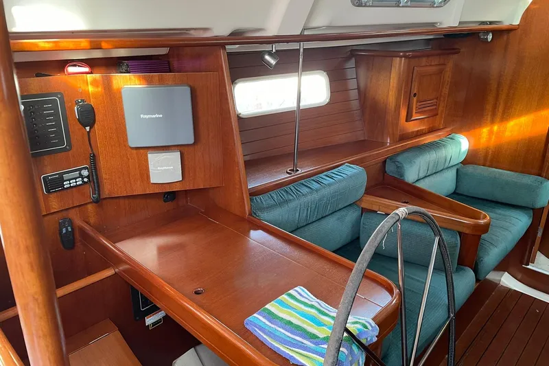 Slide: The Image of Interior of 2000 Beneteau Oceanis 361 sailboat with wood finish and teal seating. - 35