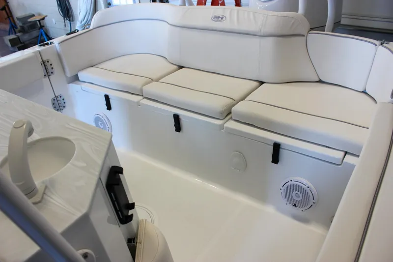 Slide: The Image of 2025 Sea Hunt Ultra 239 SE boat interior with white cushioned seating and built-in speakers. - 12