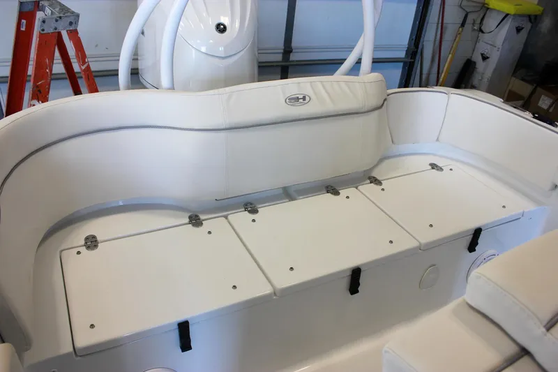 Slide: The Image of 2025 Sea Hunt Ultra 239 SE boat interior with white cushioned seating and storage compartments. - 14