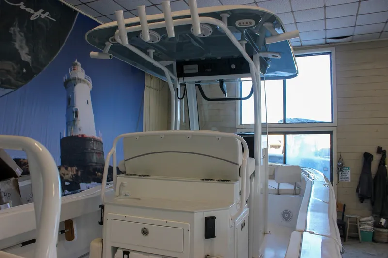 Slide: The Image of 2025 Sea Hunt Ultra 239 SE boat in showroom with lighthouse mural. - 2