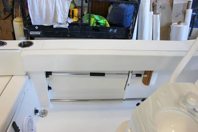 Slide: The Image of 2025 Sea Hunt Ultra 239 SE boat interior with storage and cleaning tools. - 25