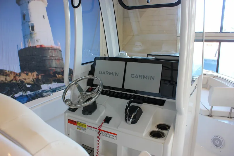Slide: The Image of 2025 Sea Hunt Ultra 239 SE boat dashboard with dual Garmin displays and steering wheel. - 26