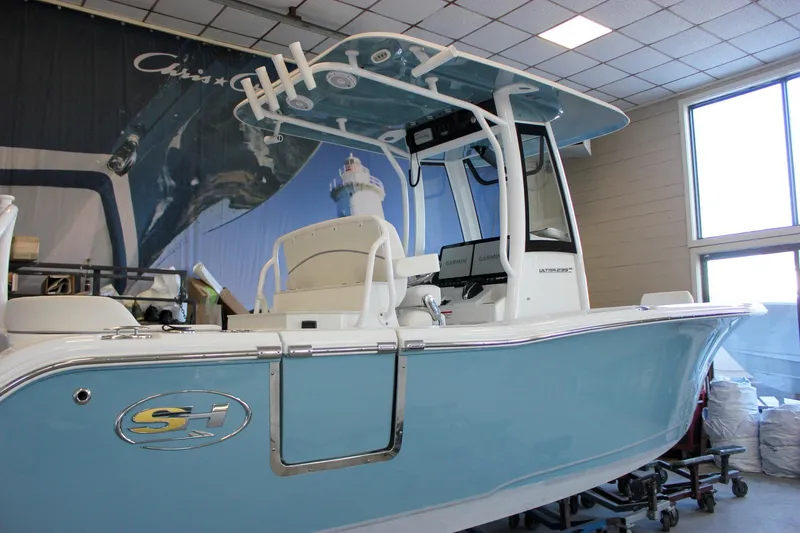Slide: The Image of 2025 Sea Hunt Ultra 239 SE boat in showroom, featuring sleek design and modern equipment. - 3