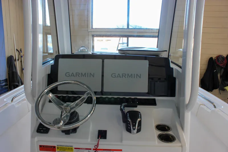 Slide: The Image of 2025 Sea Hunt Ultra 239 SE boat dashboard with dual Garmin displays and steering wheel. - 32