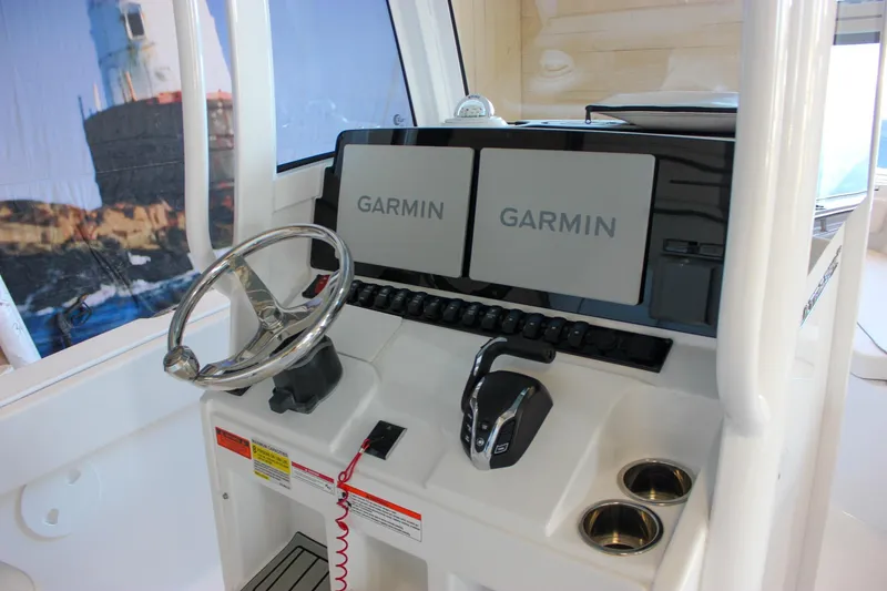 Slide: The Image of 2025 Sea Hunt Ultra 239 SE boat console with dual Garmin displays and steering wheel. - 33