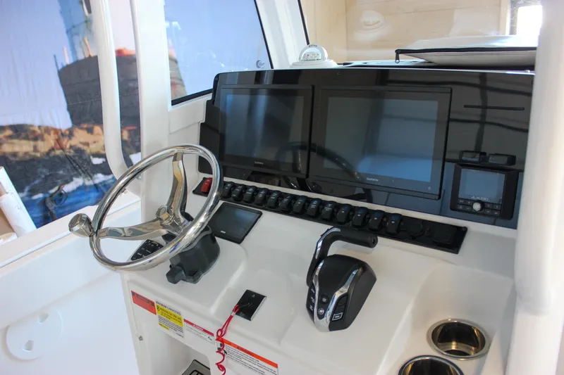 Slide: The Image of 2025 Sea Hunt Ultra 239 SE boat dashboard with dual screens and steering wheel. - 38