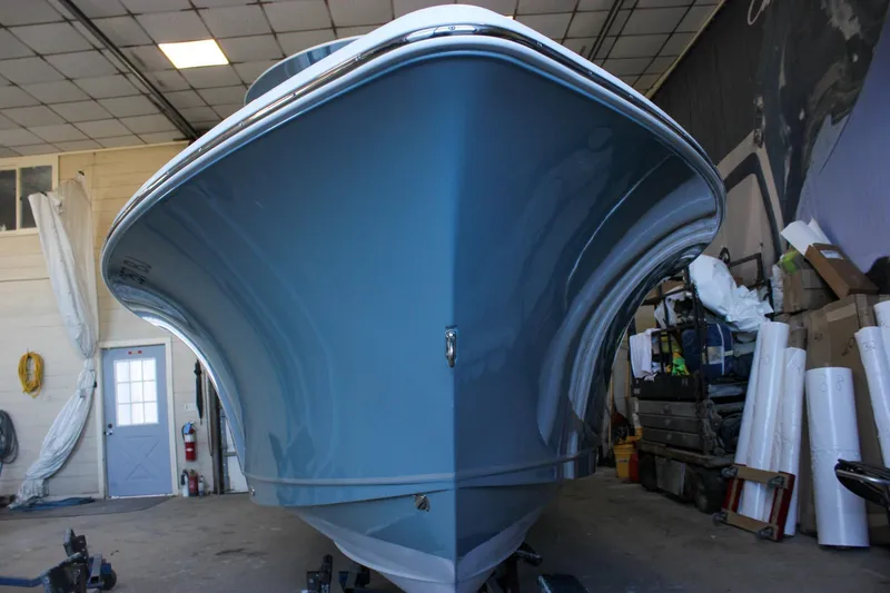 Slide: The Image of 2025 Sea Hunt Ultra 239 SE boat in a garage, showcasing its sleek blue hull design. - 4