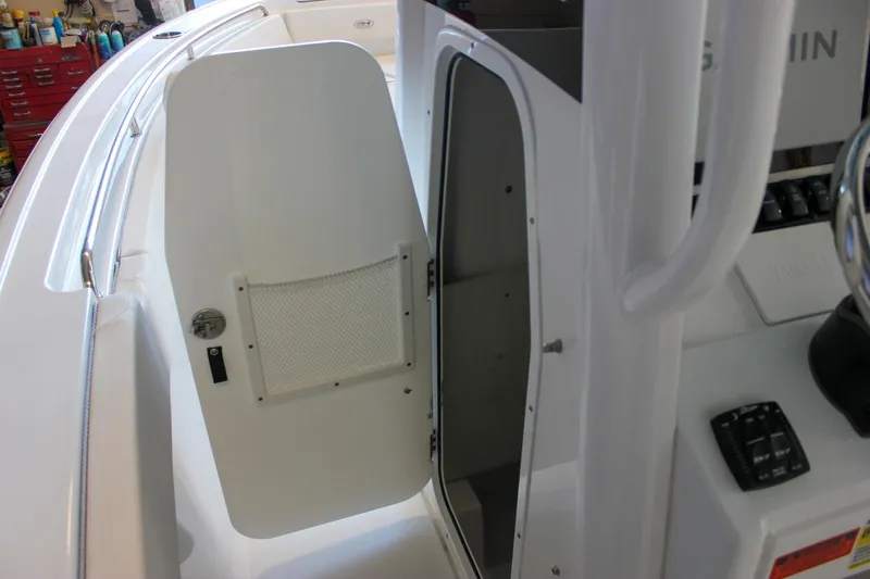 Slide: The Image of 2025 Sea Hunt Ultra 239 SE boat interior with open storage compartment door. - 41