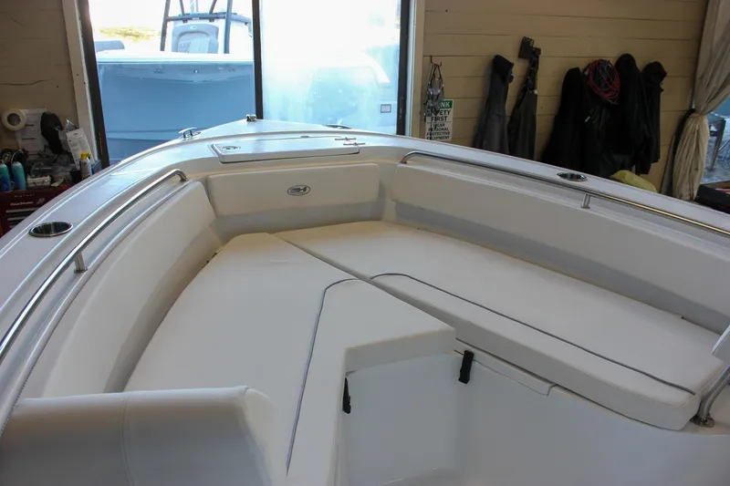 Slide: The Image of 2025 Sea Hunt Ultra 239 SE boat interior with cushioned seating in a showroom. - 42