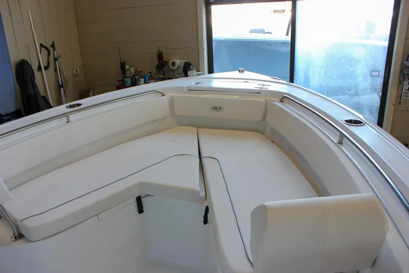 Slide: The Image of 2025 Sea Hunt Ultra 239 SE boat interior with white cushioned seating in a garage setting. - 47